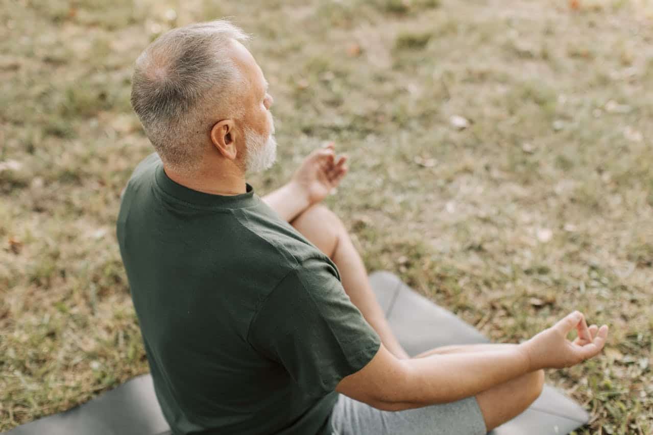 a middle aged man doing a yoga easy pose
