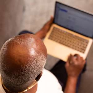 a bald man using his laptop